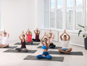 Group of people practicing yoga on mats indoors